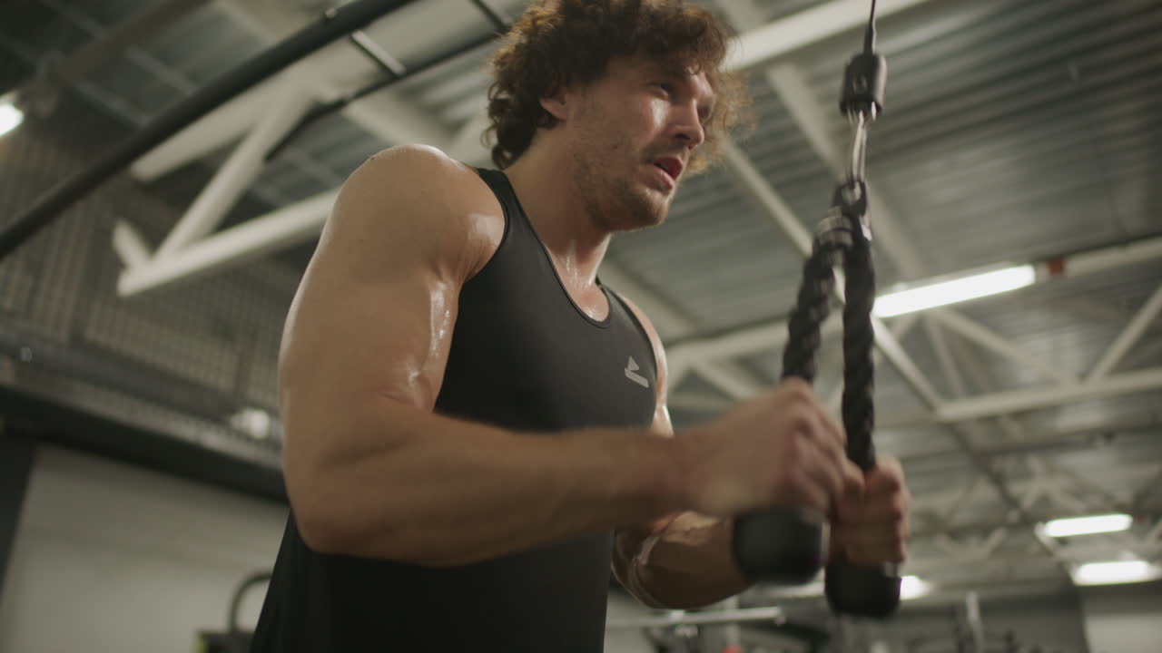 Strong Man Performing Triceps Pushdown on Pulley in Gym