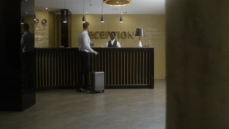 man receiving his room key at the hotel