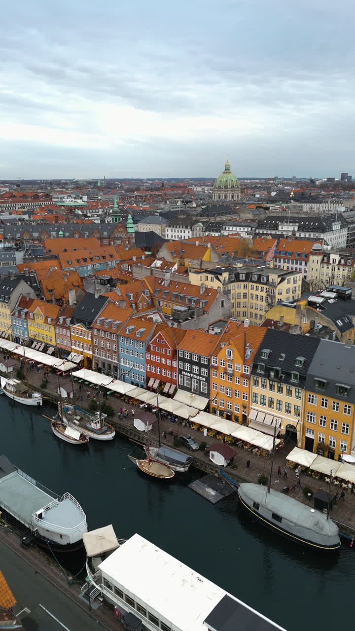 Luftfoto, der stiger op fra de mangefarvede huse og skibe i Nyhavn, København