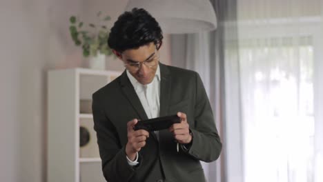 well dressed student playing mobile games before exam, standing medium shot
