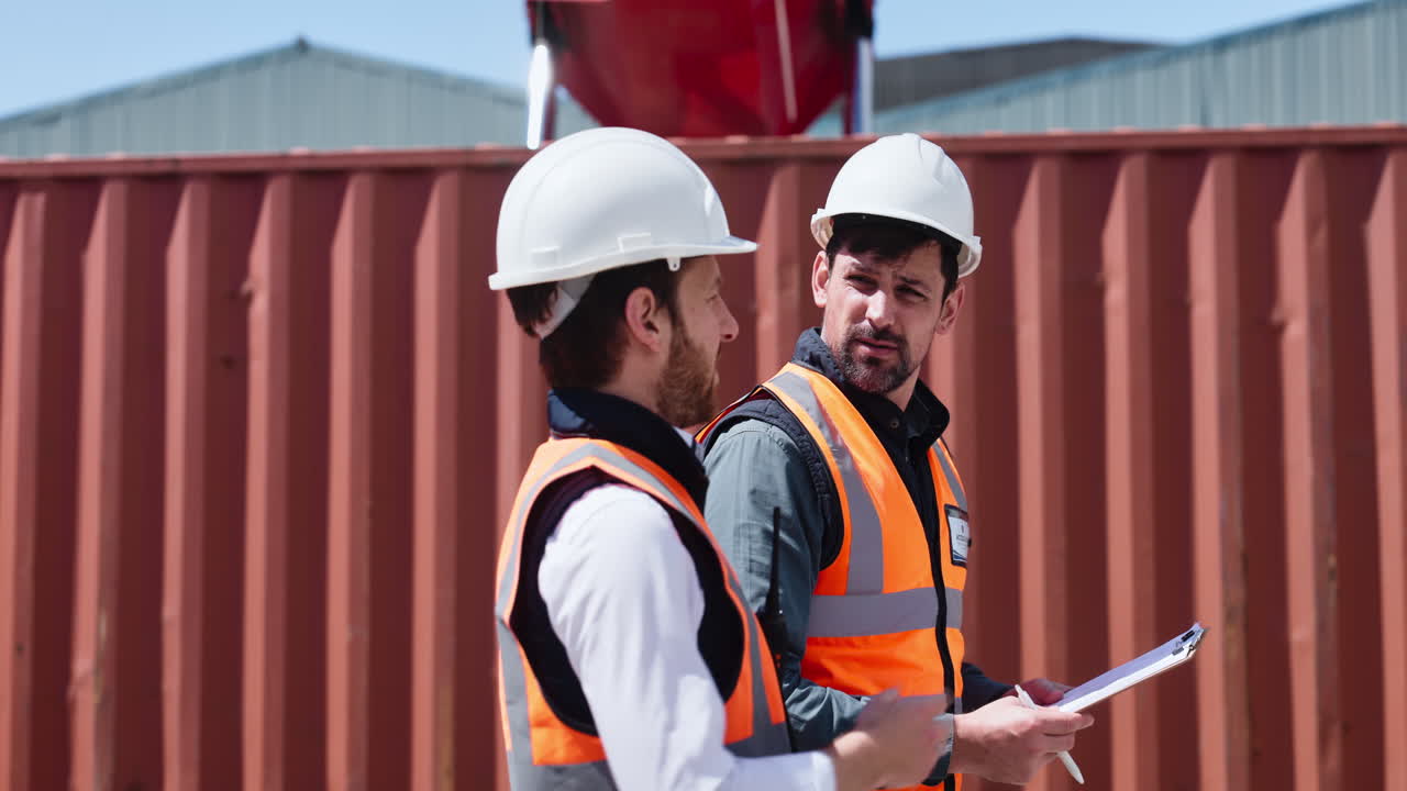 Two Engineers Discussing Plans at an Industrial Site