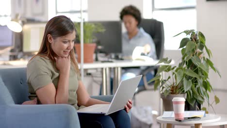 Caucasian-casual-businesswoman-making-video-call-using-laptop-in-office,-slow-motion