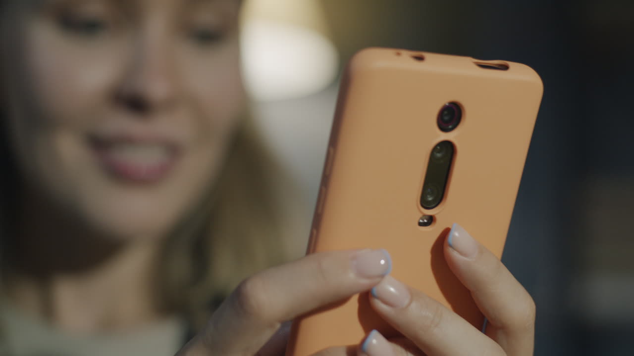 Woman looking at her orange phone
