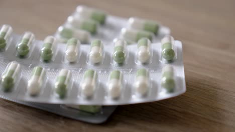 white and green capsules inside their protective sleeve for dispensing