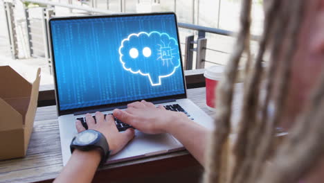 hombre de negocios biracial con rastas usando una computadora portátil con un chat digital en la pantalla