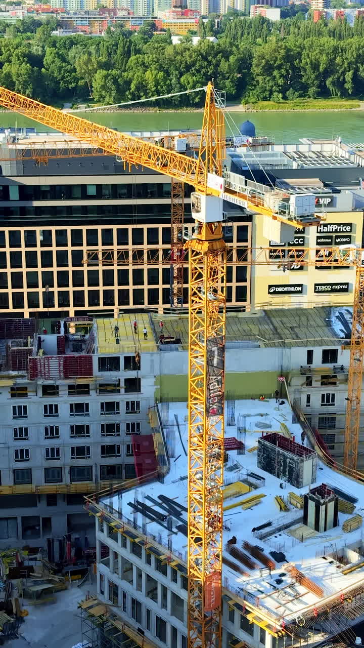 Crane at city construction site. A tall crane operates at a bustling construction site in an urban area, showcasing new building developments