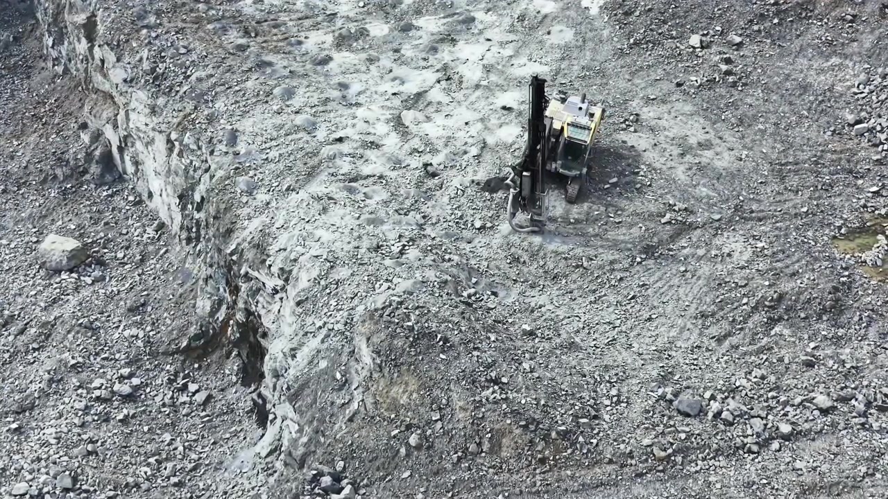Il flusso di lavoro di una cava di granito mostra macchinari pesanti che estraggono la pietra in un sito nelle prime ore del mattino.