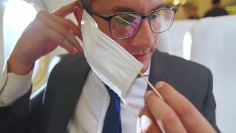 traveler wearing face mask while traveling on commercial airplane .