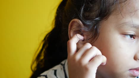 child girl having ear pain touching his painful ear ,