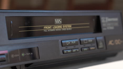 cinta de video vhs y reproductor de video, cargando la cinta y presionando el botón de reproducción, cerrar