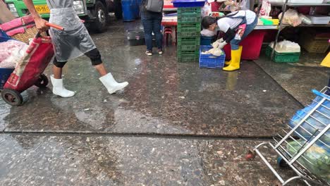 two people unloading bags from a trolley at a market