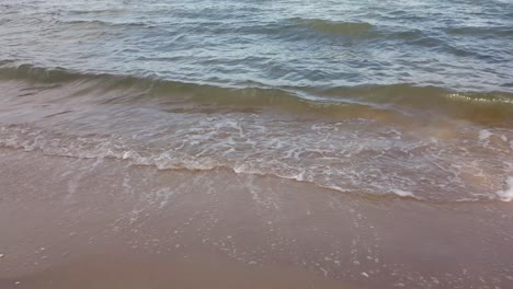 Waves-in-the-ocean-and-sand-on-the-beach,-blue-sky-sunny-day-in-Thailand