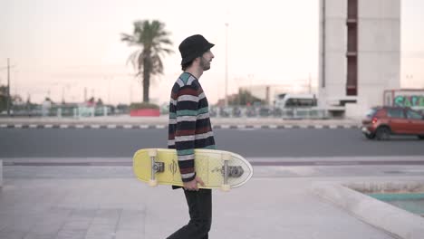 man with skateboard walking down city street