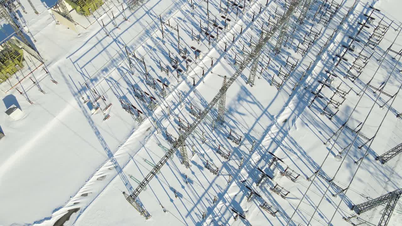 Drone view gliding above high voltage electrical substation infrastructure operating in harsh winter conditions near an AI data center in Estonia