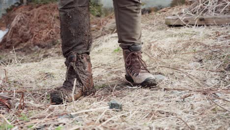 Bauernstiefel-Mit-Schlamm-Stehen-Neben-Alaskan-Malamute-Hund-Auf-Dem-Feld