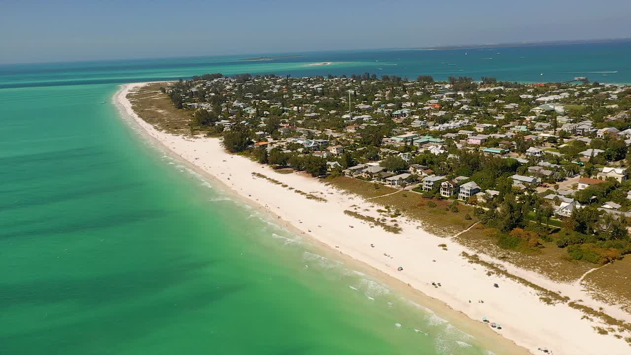 вид с воздуха на красивые дома и белый песчаный пляж на острове анна-мария во флориде