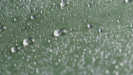 Micro-video-of-close-up-of-water-drops-with-copy-space-on-green-background