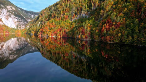 Lago-De-Montaña-En-Austria-En-Otoño-Con-El-Paisaje-Reflejándose-En-El-Agua---Aéreo