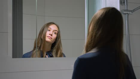 mujer joven mirando en el espejo del baño, cámara lenta