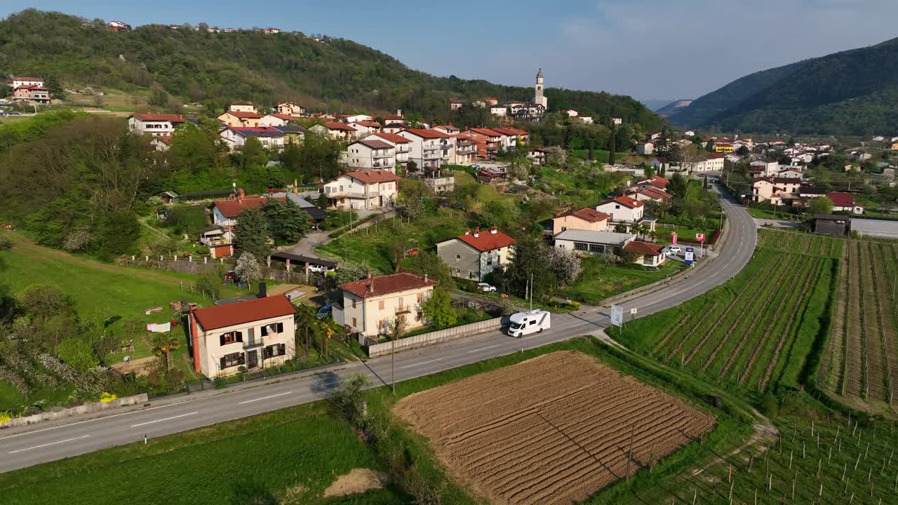 Aerial dolly in view of Vipava, small town in Slovenia, with green vineyards, rural fields and rustic homes