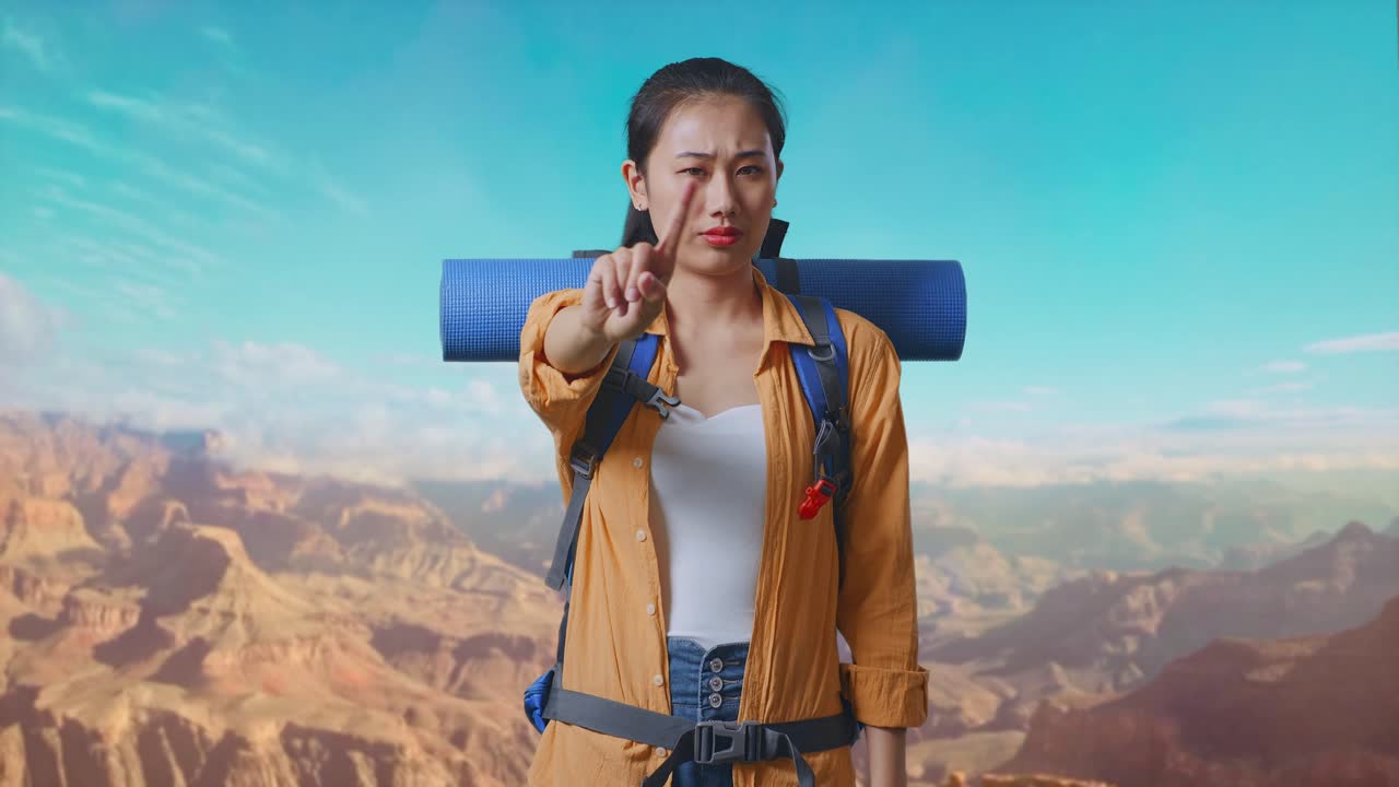 Asian Female Hiker With Mountaineering Backpack Showing No Gesture With Index Finger While Traveling At The Top Of Mountain