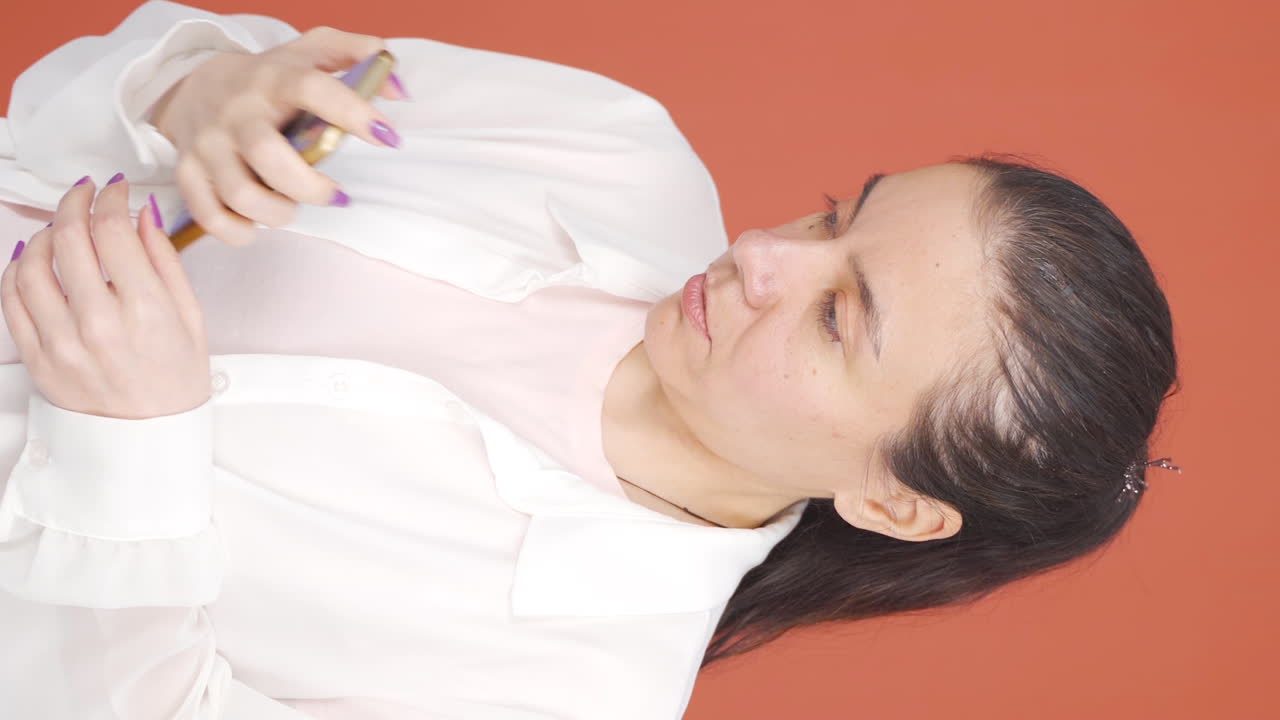 여성이 전화로 나쁜 소식을 듣는 수직 비디오가 화가 납니다.