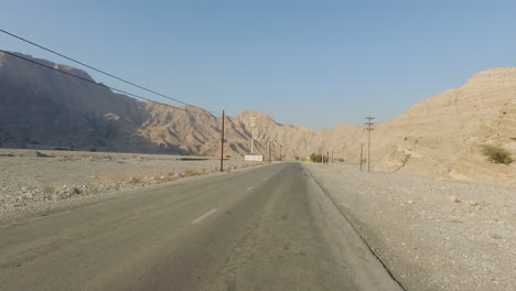 Shot-of-mountain-range-and-desert-road-from-car