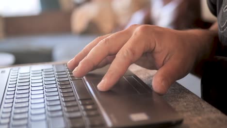 Man-typing-on-laptop-keyboard-working-at-home