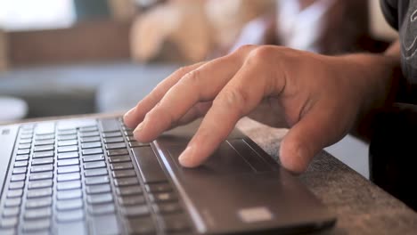 hombre escribiendo en el teclado de la computadora portátil trabajando en casa