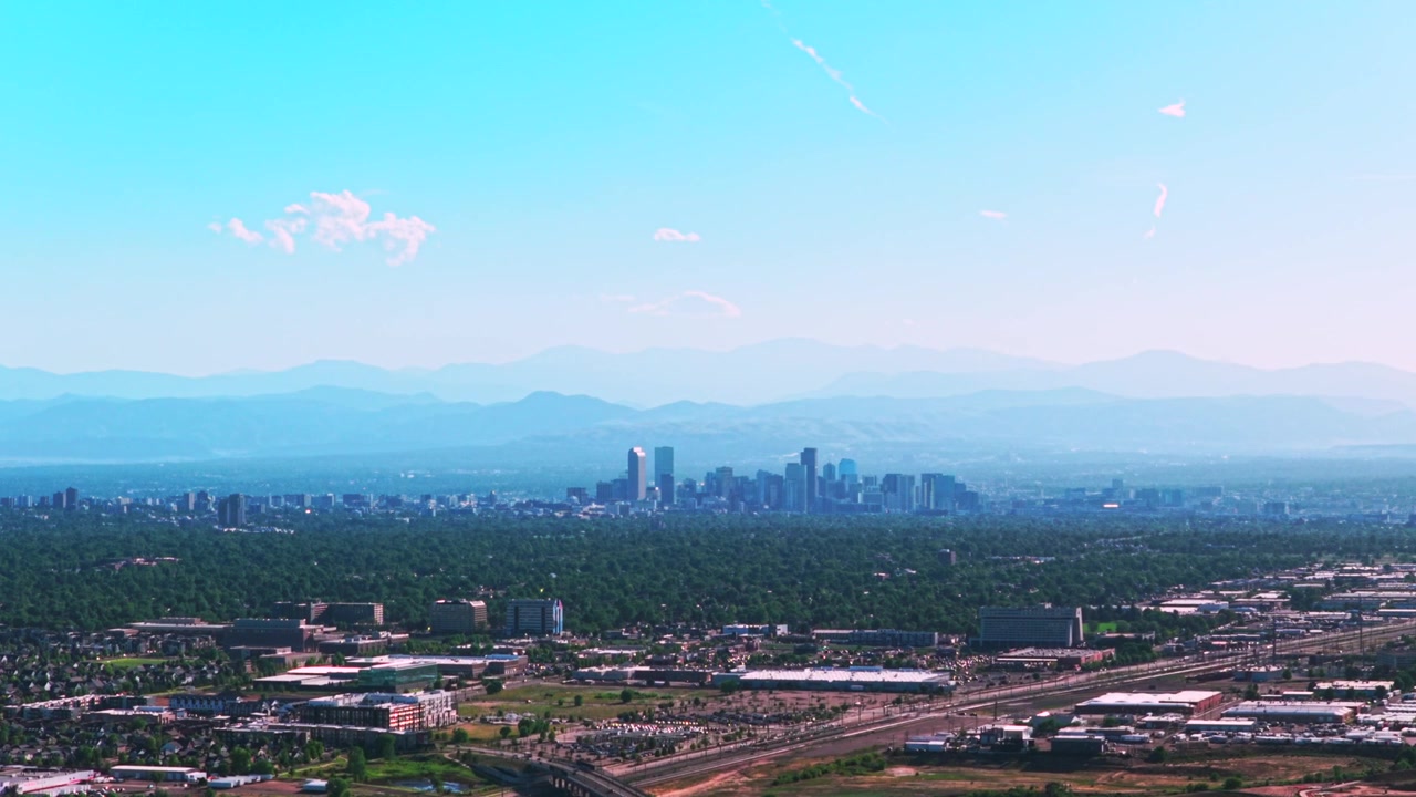 Denver, Colorado: skyline del centro, grattacieli, edifici, vista aerea con drone. Autostrada, auto, pedemontana delle Montagne Rocciose. Strati, estate, primavera, foschia, cieli azzurri e sereni, mattino.