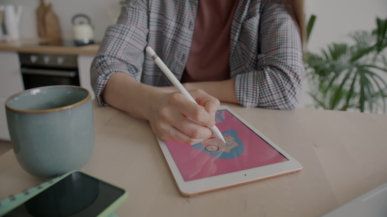Woman working on digital art on a tablet at home