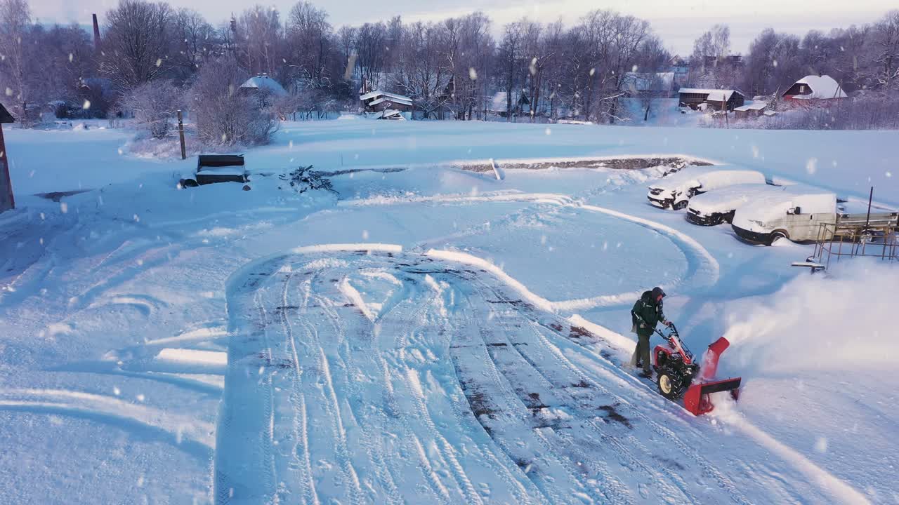 폭설 동안 농촌 지역의 주차장에서 사람이 눈을 날려