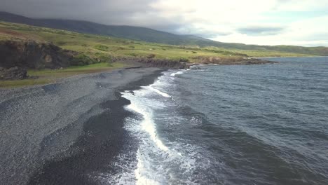 Waves-crash-ashore-along-the-black-coastline