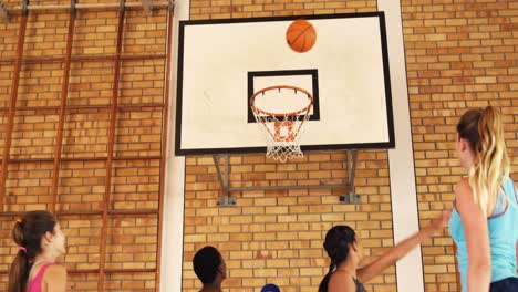 coach helping high school team to score a goal while playing basketball