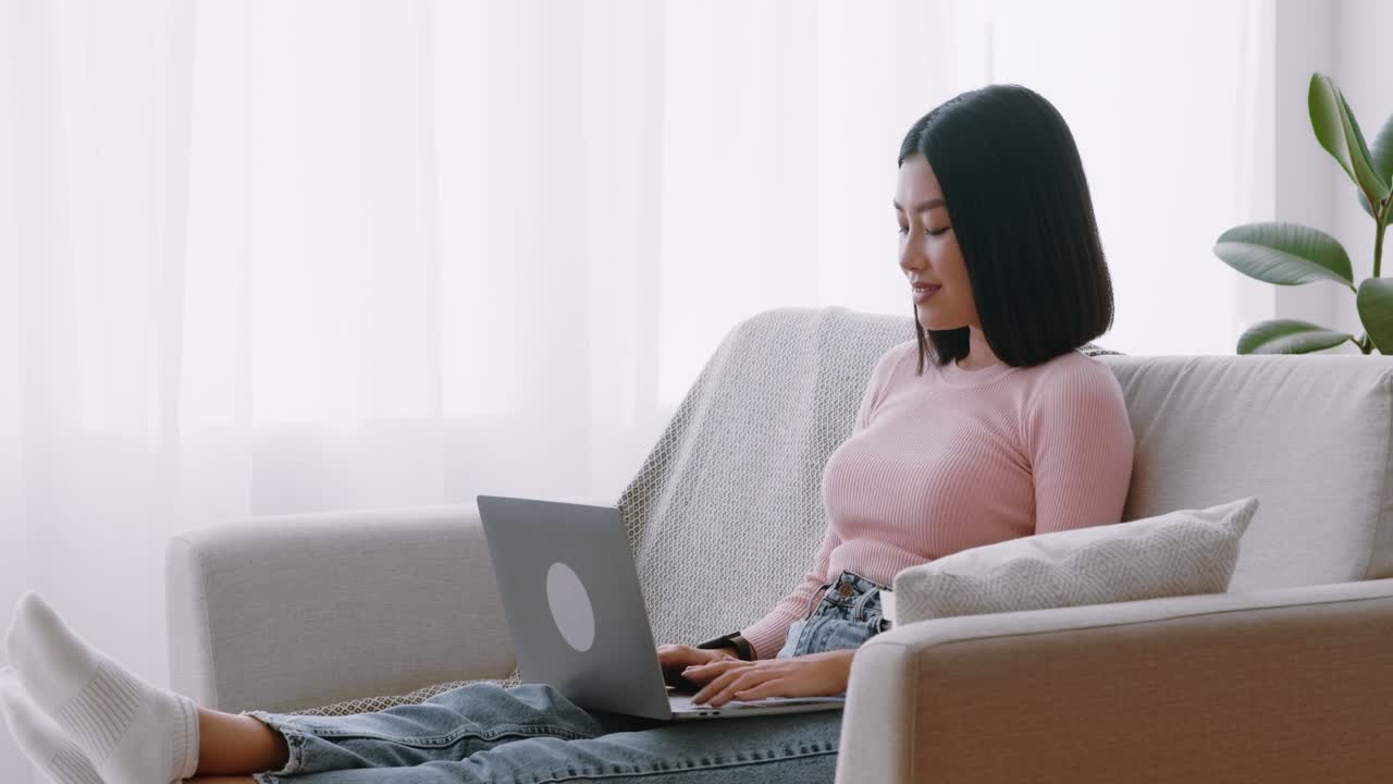 노트북으로 집에서 일하는 젊은 여성