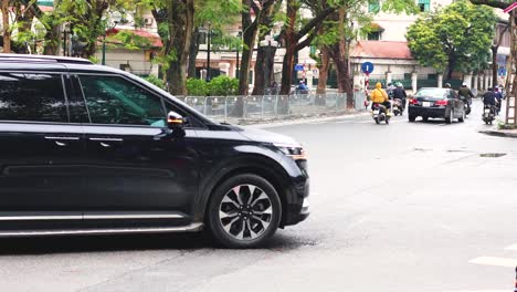 motorcycles and cars navigate a bustling intersection