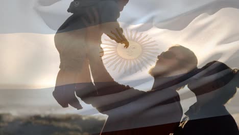 animación de la bandera de argentina sobre una familia caucásica en la playa