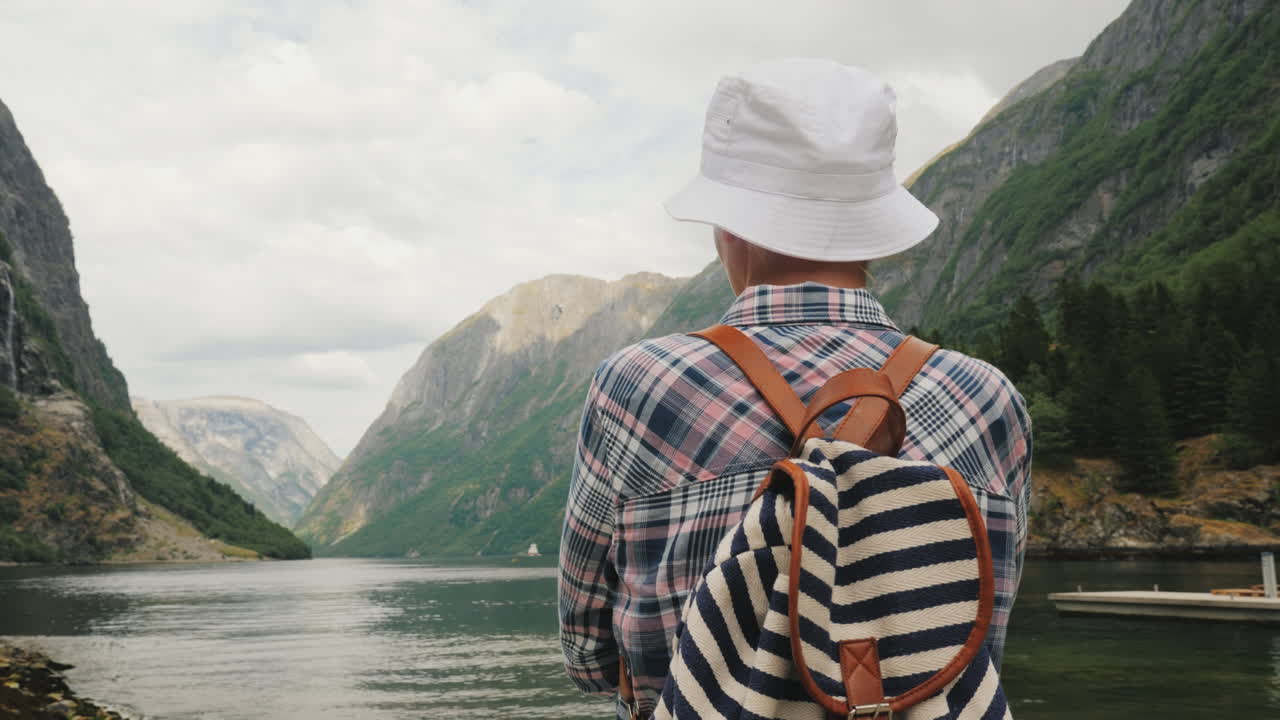 un turista con una mochila en la espalda admira el pintoresco fiordo en noruega estilo de vida activo y t