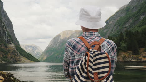 Ein-Tourist-Mit-Rucksack-Auf-Dem-Rücken-Bewundert-Den-Malerischen-Fjord-In-Norwegen-Aktiven-Lebensstil-Und-T