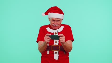 Worried-grandfather-in-Christmas-t-shirt-enthusiastically-playing-racing-video-games-on-mobile-phone