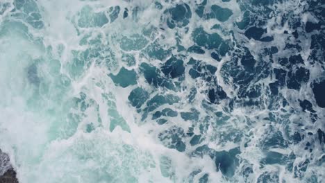 Turquoise-Seascape-With-Foamy-Waves-In-Arteixo,-Spain---aerial-top-down