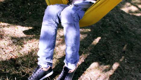 Man-sitting-in-a-hammock-outdoors