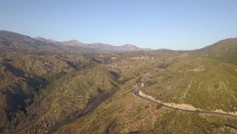 Drone-flying-high-over-mountain-pass-road