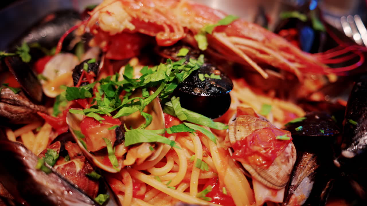 Close up of pasta with tomato sauce and mussels in a pan