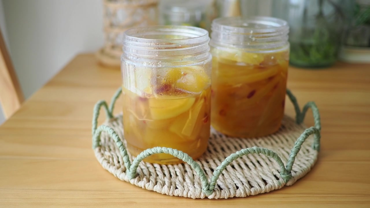 Two Jars of Homemade Peach Jam on a Wooden Table