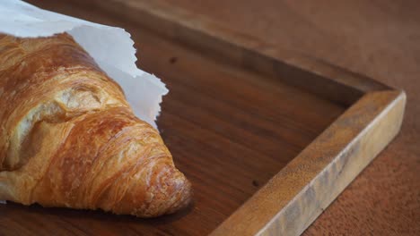 un delicioso croissant en una bolsa de papel