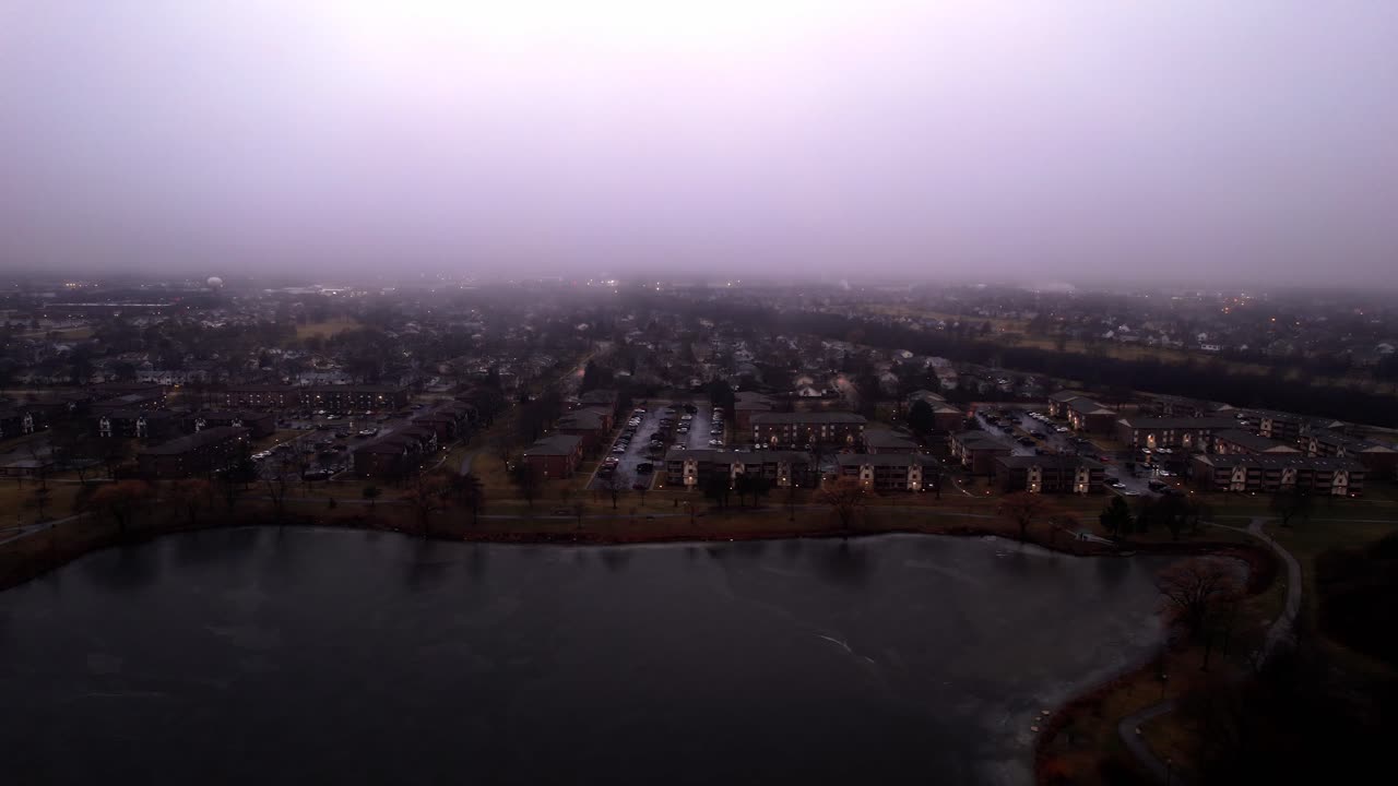aerial of vernon hills residential houses located next to century park sledding hill at blue hour - twilight sorounded by mist