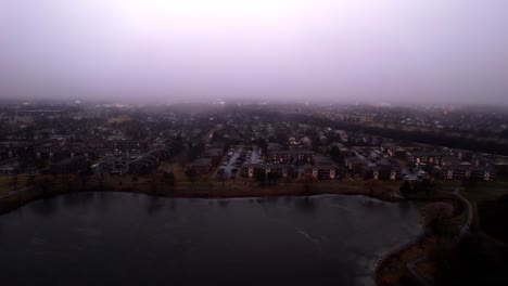 aerial of vernon hills residential houses located next to century park sledding hill at blue hour - twilight sorounded by mist