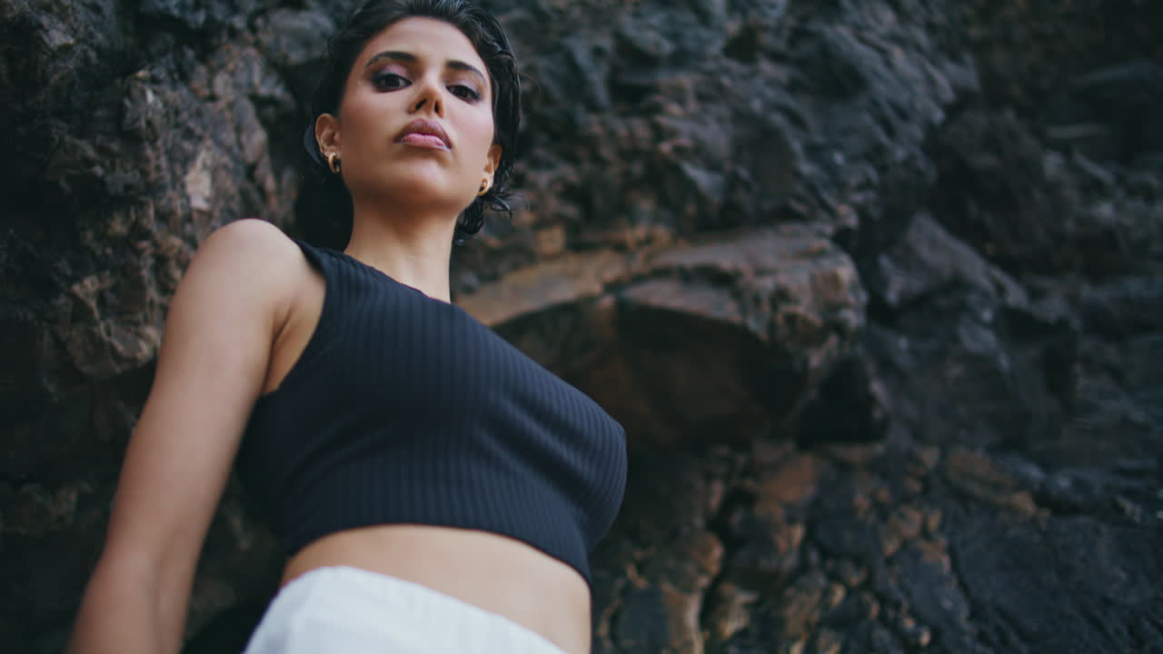 Attractive girl resting seaside closeup. Stylish fashion model posing cliff