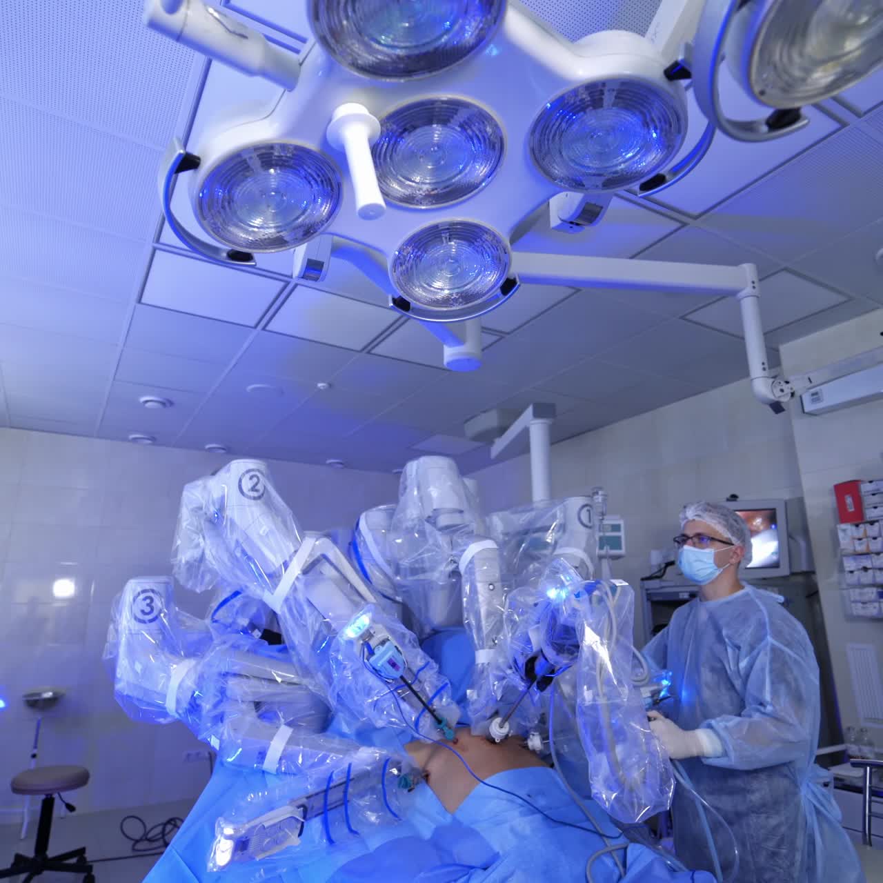 Futuristic surgery in modern operating room. Robotic machine perform minimally invasive surgery. Doctors observe the work of surgical robot in hospital.